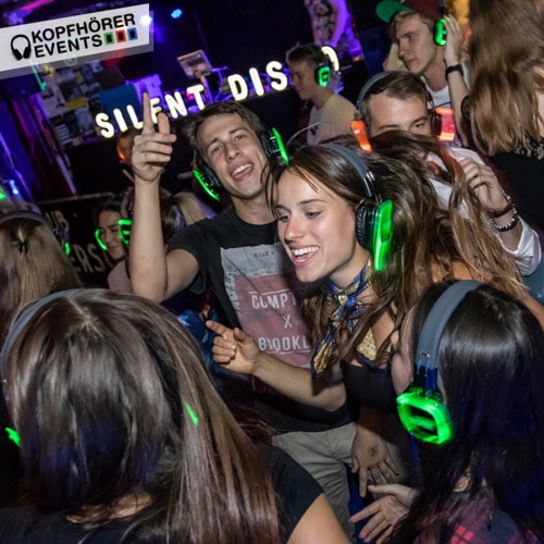 Tanzende junge Menschen auf einer Club Kopfhörerparty mit Silent Disco Kopfhörern