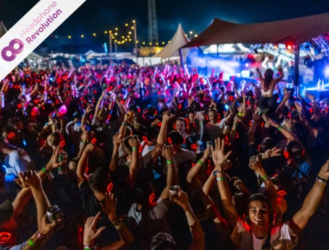 Sehr viele Menschen feiern auf einem Festival bei einer Silent Disco mit Neon Lights Plus+ Kopfhörern.