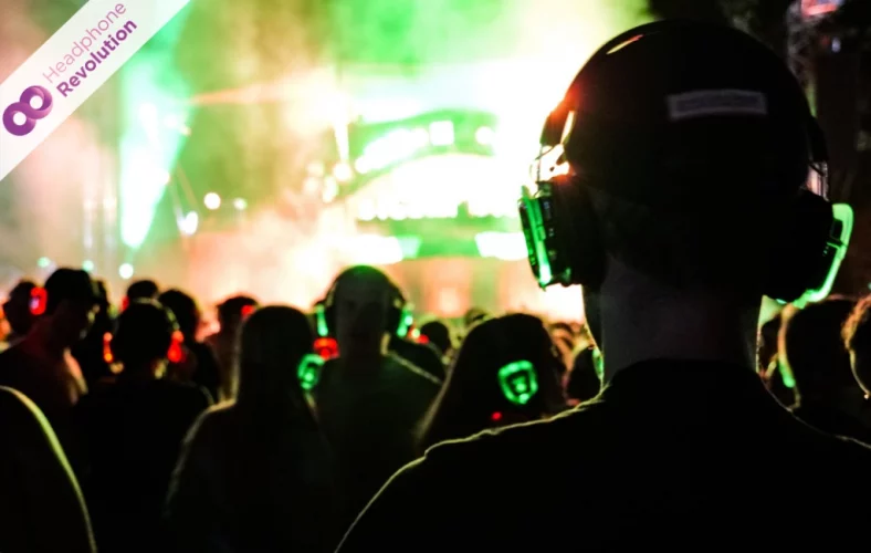 Menschen feiern mit Silent Disco Kopfhörer auf dem Happiness Festival zu verschiedenen Musikrichtungen gleichzeitig.