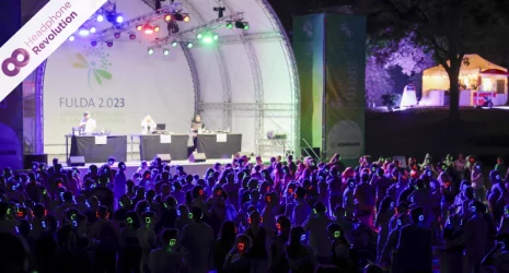 Viele Menschen tragen spezielle Silent Disco Kopfhörer von Headphone Revolution bei einer Kopfhörerparty auf der Langesgartenschau in Fulda.