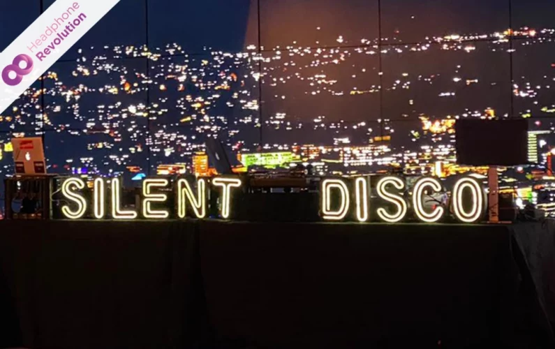 Ein Silent Disco LED-Schriftzug auf einem DJ Pult bei einer Kopfhörer Party.
