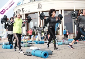 Sportlerinnen beim Silent Fitness trainieren Outdoor und tragen dabei spezielle Silent Kopfhörer von Headphone Revolution.