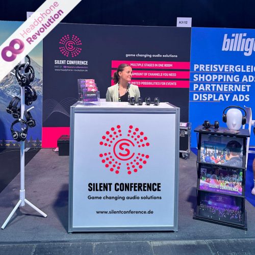 Eine Silent Conference Mitarbeiterin an ihrem Expo Stand auf der OMR 2024 mit mehreren Kopfhörermodellen.