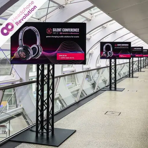 Mehrere Displays projizieren Silent Conferernce part of Headphone Revolution Werbung in einem Gang auf der OMR in Hamburg.