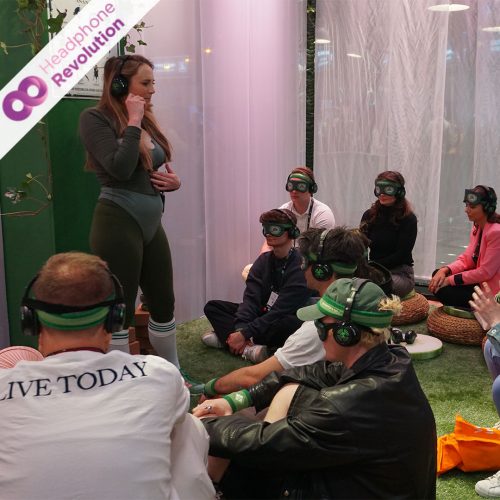 Ein Yogakurs macht Yoga benutzt das Kopfhörersystem von Headphone Revolution auf dem Online Marketing Rockstars Festival.