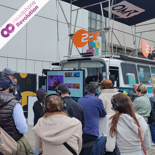 Eine Menschenmenge vor dem ZDF Stand auf der OMR 2024 in Hamburg tragen Silent Conference Kopfhörer von Headphone Revolution.