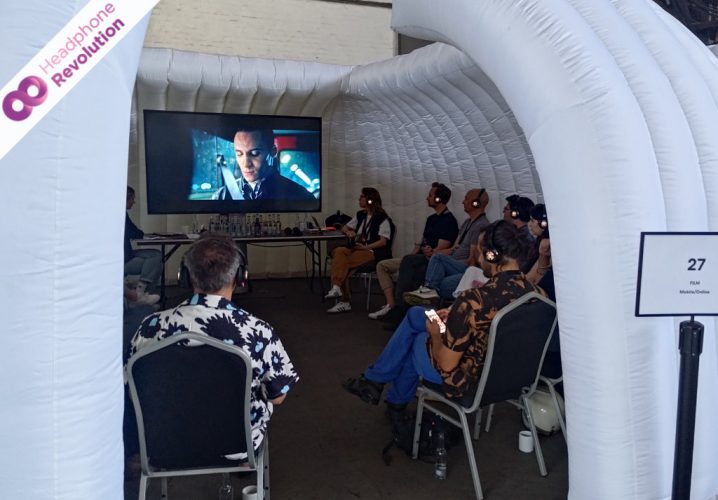 Eine Gruppe von Menschen in einem Quickspace beim ADC Festival schauen einen Film mit Silent Conference Kopfhörern von Headphone Revolution.