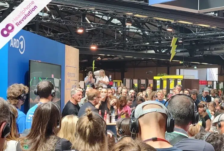 Viele Menschen tragen Silent Conference Kopfhörer am ARD und das Erste Stadt auf einer Messe, bei dem der ehemalige Fußball Weltmeister Bastian Schweigsteiger einen Vortrag hält und der Ton auf die Kopfhörer übertragen wird.