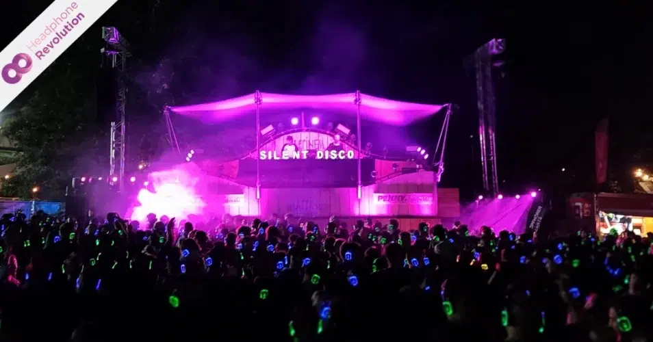 DJs spielen auf einem Bühne bei dem Happiness Festival bei dem die Musik über Silent Disco Kopfhörer übertragen wird.