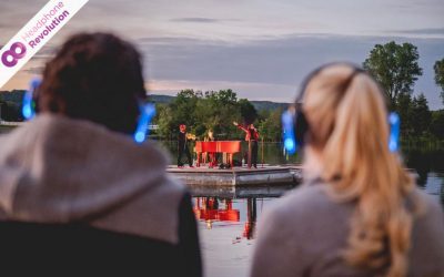 Ein Pärchen trägt auf einem Konzert Silent Kopfhörer von der Firma Headphone Revolution auf die der Ton des Live-Auftritts übertragen wird.