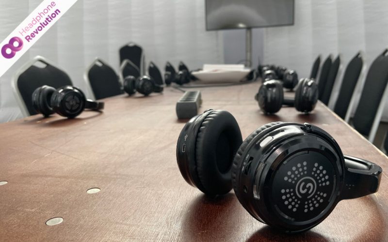 Spezielle Silent Conference Kopfhörer liegen verteilt bei einer Konferenz auf einem Tisch.