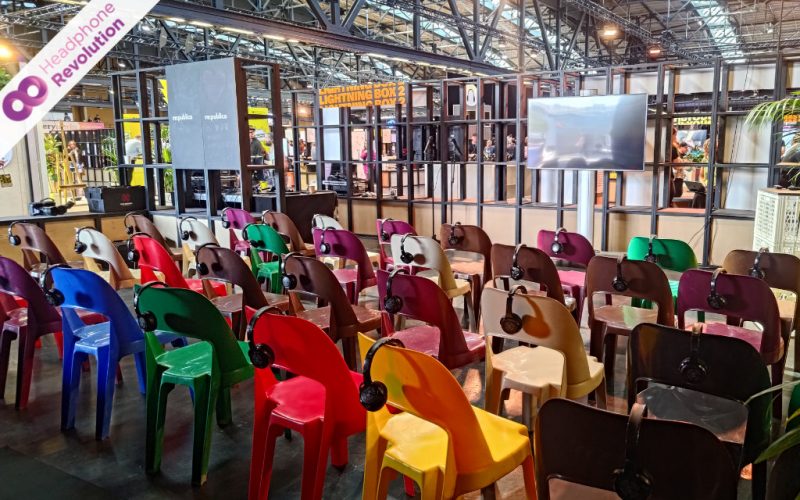 Silent Conference Kopfhörer des Modells HR SC Flex von Headphone Revolution hängen auf Stühlen bei einer Messe in der Arena Berlin.