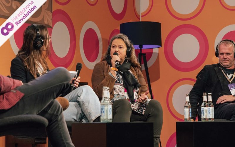 Ein Panel Talk auf einer Konferenz, bei dem die Teilnehmer in ein Mikrofon sprechen und der Ton auf spezielle Silent Conference SCF Kopfhörer übertragen wird.