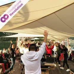 Einige Leute feiern und tanzen bei einer Kopfhörerparty auf einem Schiff.