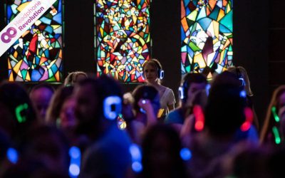 Menschen singen und tanzen bei einer Kopfhörerparty im Landesmuseum in Stuttgart und tragen dabei das Silent Disco System "Neon Lights" von Headphone Revolution.