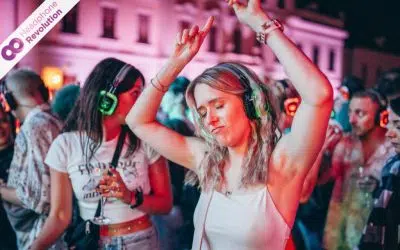 Eine Frau feiert und tanzt ausgelassen in der Menschenmenge auf dem Melodic Wine Festival in Ludwigsburg bei einer Silent Disco mit speziellen Kopfhörern.