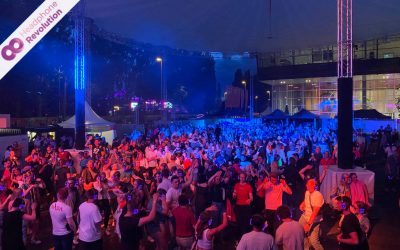 Eine Masse an Telekom Mitarbeitern trägt die lila leuchtenden Silent Disco Kopfhörer und feiert ihr Mitarbeiterfest mit einer Silent Disco.