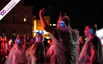 Einige Personen tanzen und singen im Regen bei einer Silent Disco bei der UEFA Europameisterschaft in Stuttgart und hören die Musik über die Silent Disco Kopfhörer von Headphone Revolution.