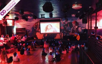 Eine Grupper Kinder schaut einen Kinderfilm und hört dabei den Ton über spezielle Kopfhörer von Headphone Revolution, um die Konzentration zu steigern und den Lautstärkepegel zu senken.