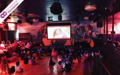 Eine Grupper Kinder schaut einen Kinderfilm und hört dabei den Ton über spezielle Kopfhörer von Headphone Revolution, um die Konzentration zu steigern und den Lautstärkepegel zu senken.