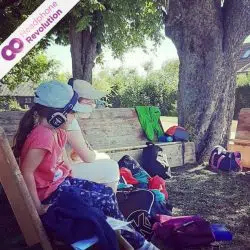 Auf einer Kinderfrzeit hören zwei Kinder in der Mittagspause eine Geschichte, die auf Silent Disco Kopfhörer von Headphone Revolution übertragen wird.