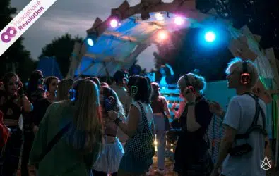 Einige Personen tanzen und feiern auf dem Ilmpuls Festival auf einer Silent Disco und hören die verschiedenen Musikrichtungen über die Silent Disco Kopfhörer von Headphone Revolution.