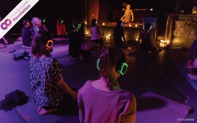 In einem Club machen Menschen Yoga mit Silent Disco Kopfhörern.