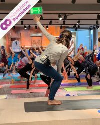 Bei einem Silent Yoga Event in einem Einkaufszentrum wird der Ton der Trainerin nicht über eine laute Musikanlage übertragen, sondern stattdessen über spezielle Silent Disco Kopfhörer von Headphone Revolution.