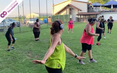 Eine Frauengruppe, die an einem Outdoor Fitness Kurs teilnimmt und dafür Silent Fitness Kopfhörer von Headphone Revolution nutzt.