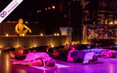 Einige Personen, die eine Entspannungsübung in einem Silent Yoga Kurs durchführen und dabei die Silent Fitness Kopfhörer nutzen, auf die die Musik übertragen wird.