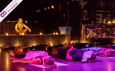 Einige Personen, die eine Entspannungsübung in einem Silent Yoga Kurs durchführen und dabei die Silent Fitness Kopfhörer nutzen, auf die die Musik übertragen wird.