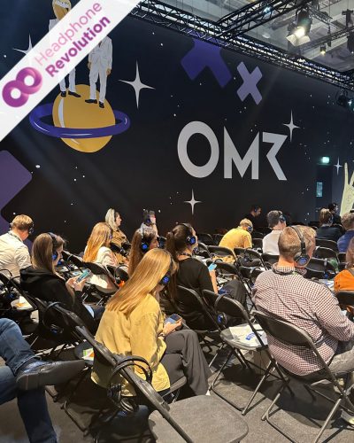 Teilnehmer einer Masterclass auf dem OMR Festival 2024 tragen Silent Conference Kopfhörer von Headphone Revolution über die der Ton der Referenten übertragen wird.