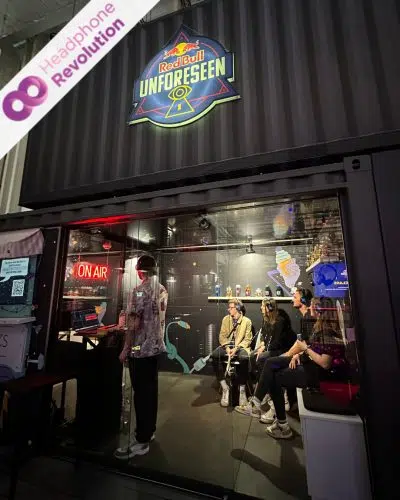Menschen, die Silent Conference Kopfhörer tragen und bei einem Live-Podcast von Podstars am Red Bull Stand auf dem OMR Festival zuhören.