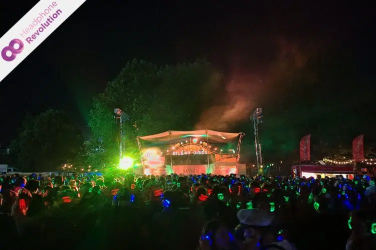 Eine riesige Menschenmasse feiert bei einer Silent Disco auf dem Happiness Festival 2024 und hört die verschiedenen Musikrichtungen über die Silent Disco Kopfhörer von Headphone Revolution.