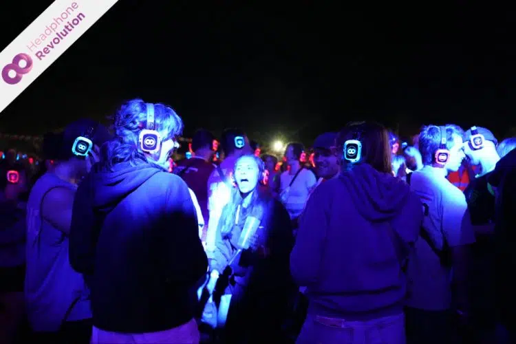 Eine Gruppe von Freunden feiert ausgelassen auf einer Kopfhörerparty beim Happiness Festival.