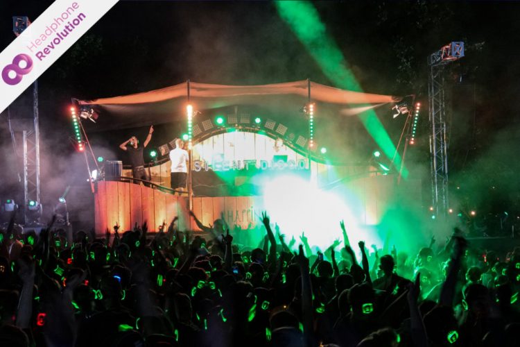 Eine Menschenmasse feiert vor der Silent Disco Bühne auf dem Happiness Festival in Pforzheim ausgelassen und hört die verschiedenen Musikrichtungen über die Silent Disco Kopfhörer von Headphone Revolution.