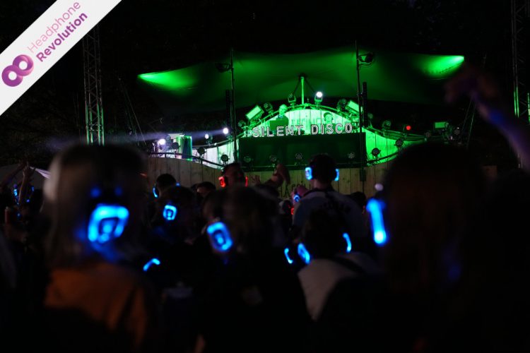 Viele Menschen feiern bei einer Silent Party vor der Bühne auf dem Happiness Festival in Pforzheim und hören die Musik über Silent Disco Kopfhörer.