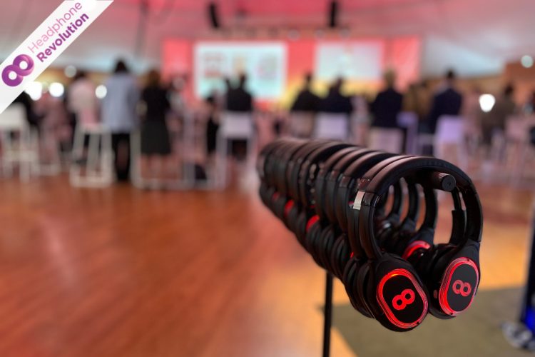 HRT12PRO Kopfhörer hängen an einem Kopfhörerständer während im Hintergrund eine Silent Conference läuft